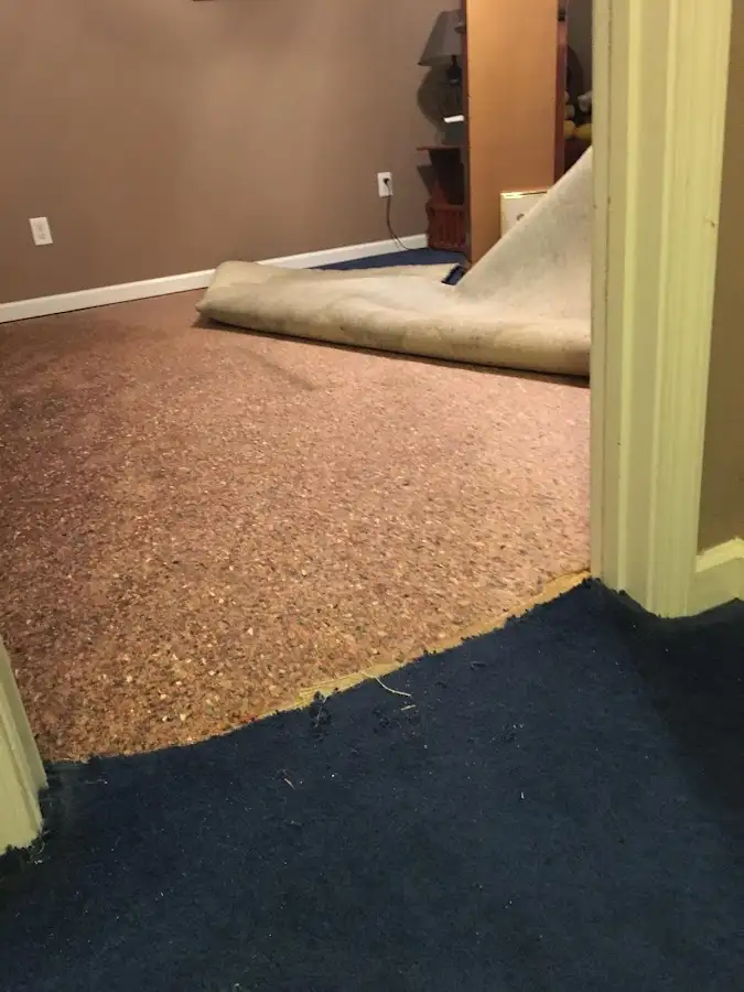 Carpet pad removal revealing water damage during Water Mitigation Services in Liberty